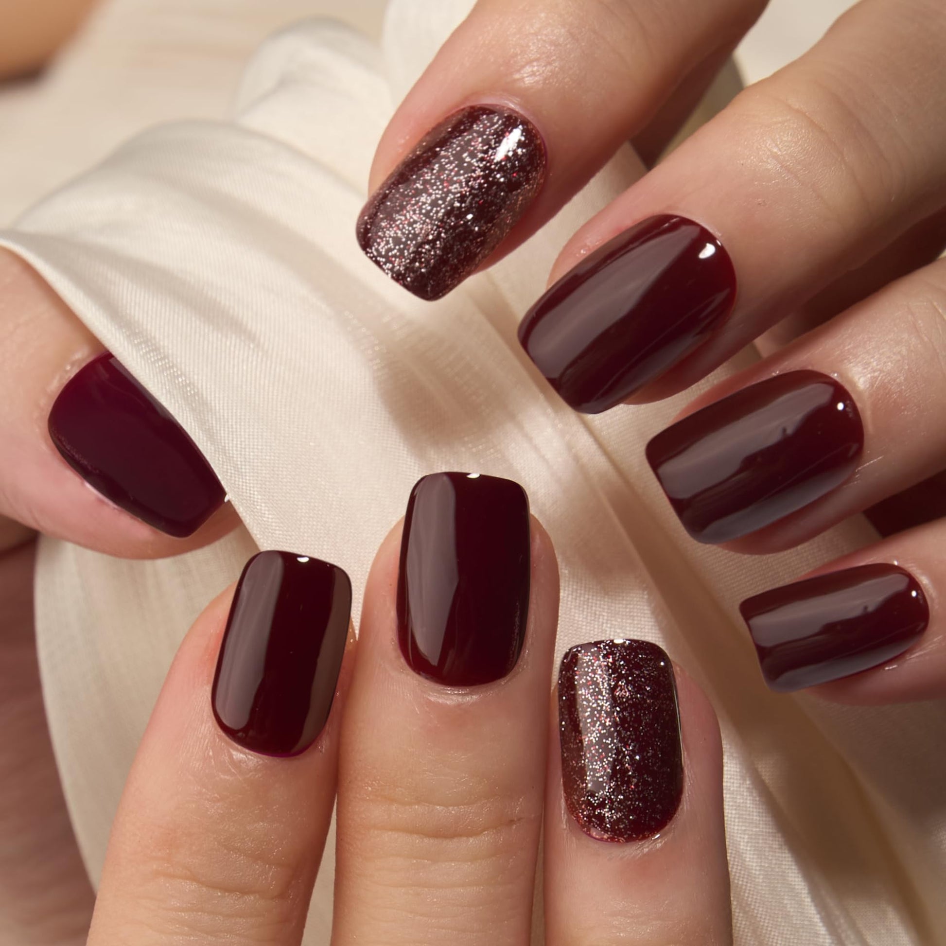Close up of Curvlife wine red and rose gold glitter accent nails