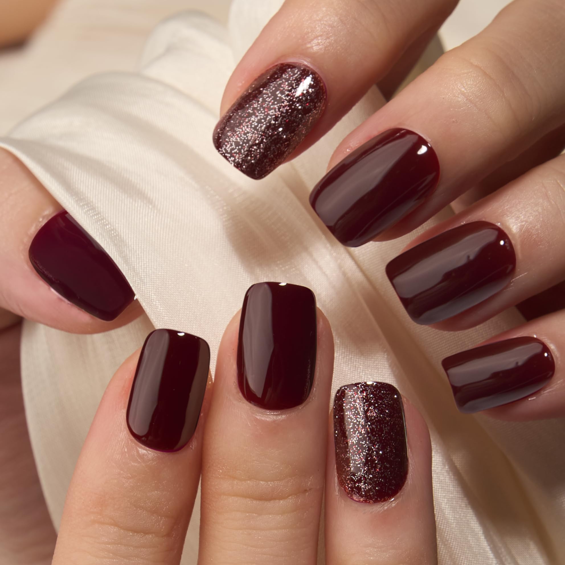 Close up of Curvlife wine red and rose gold glitter accent nails