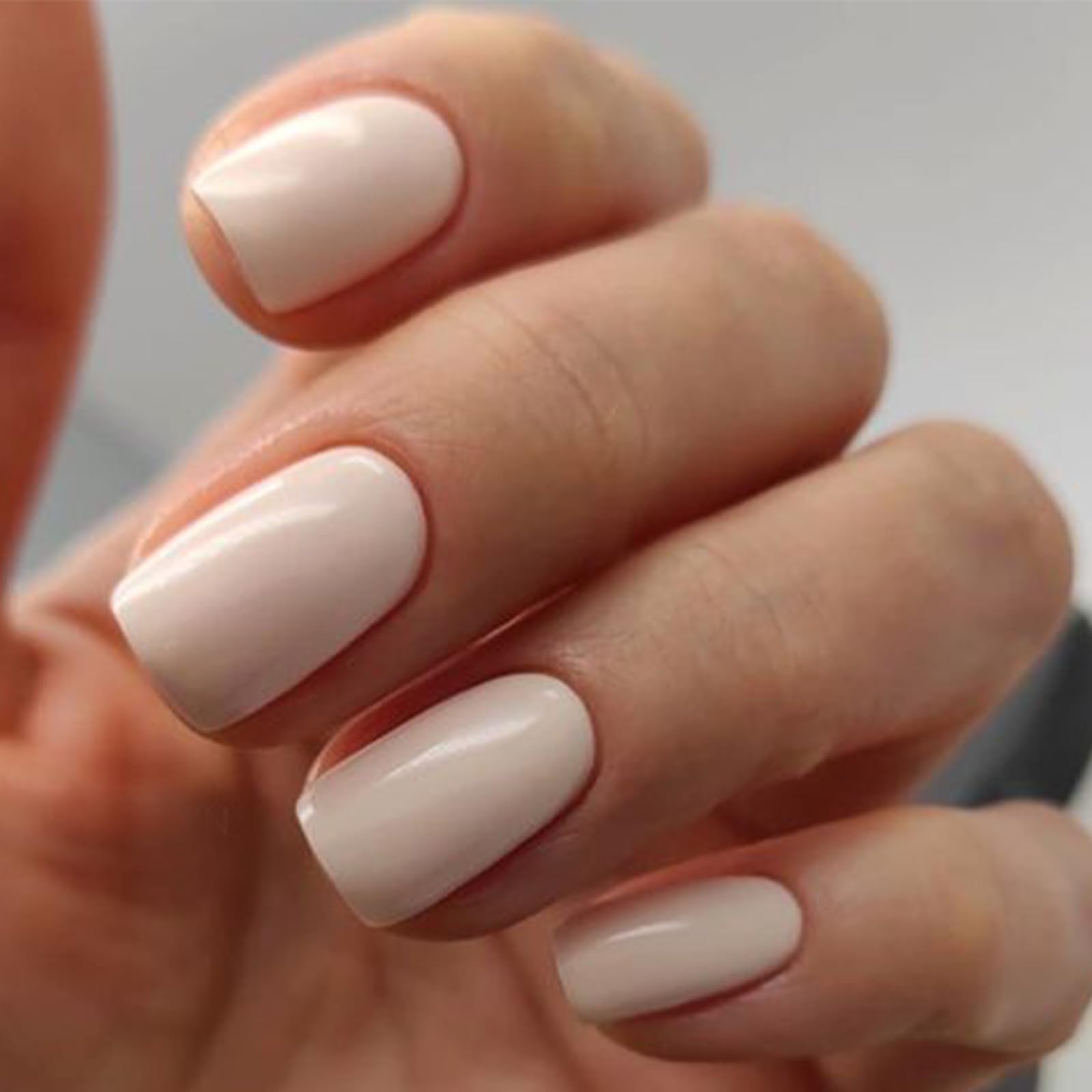 Close up of milky white short square fake nails