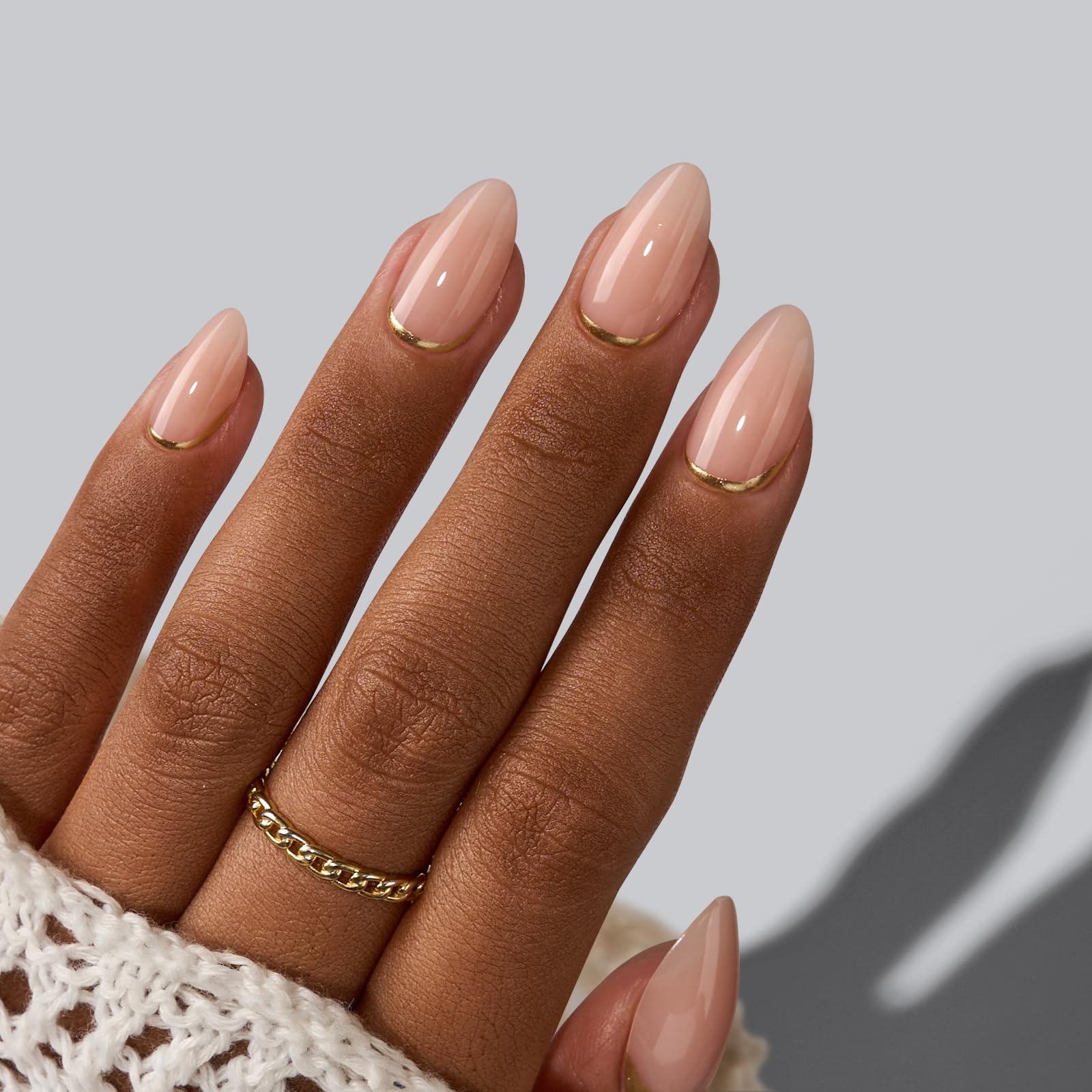 Close up of gold foil almond shaped press on nails