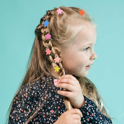 Assorted pastel and vibrant matte colors of the mini flower hairpins scattered on a clean surface.
