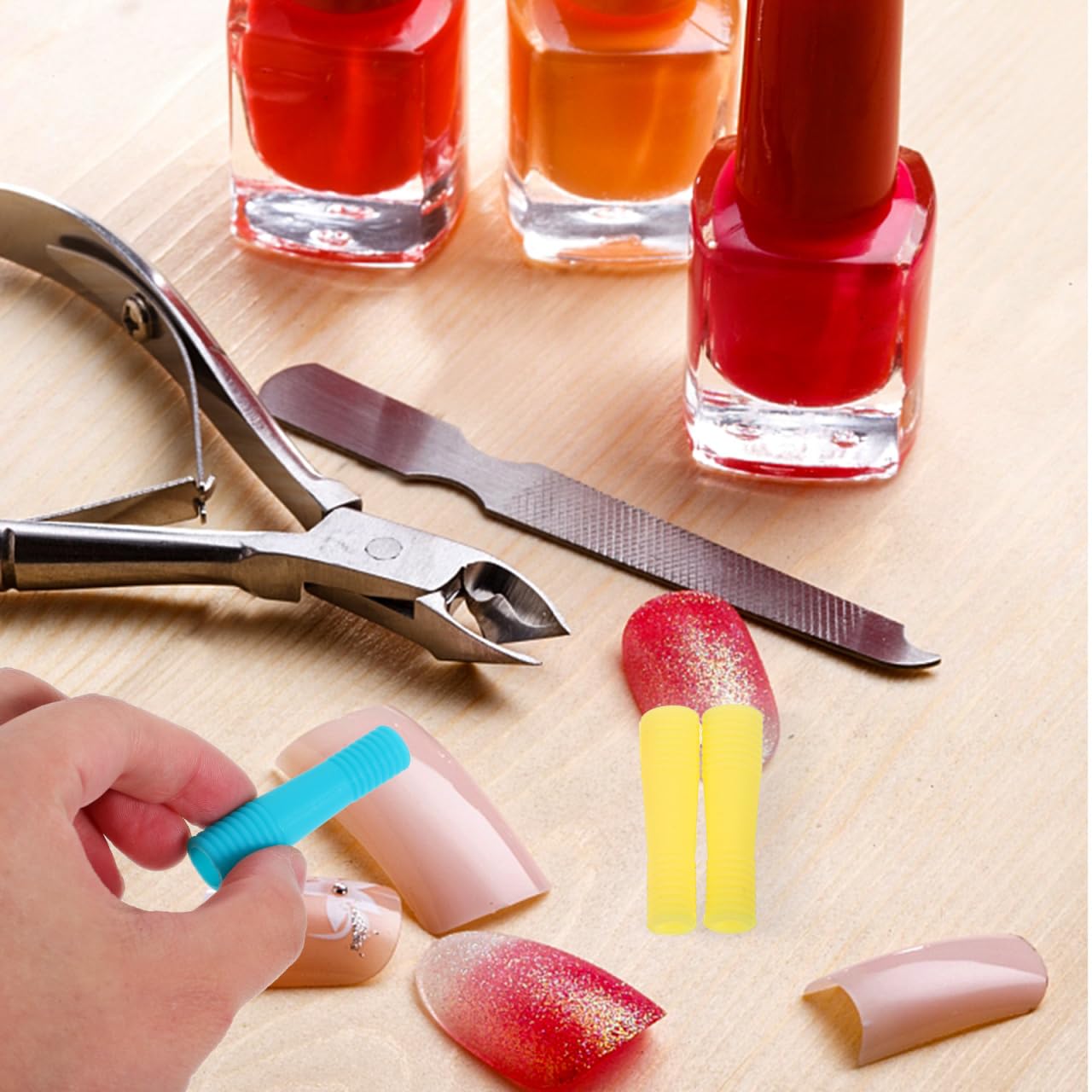 Assorted yellow pink and blue ergonomic silicone sleeves designed to prevent finger fatigue during home manicures.