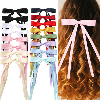 Side view of dark black long tail hair bow barrette highlighting fabric quality
