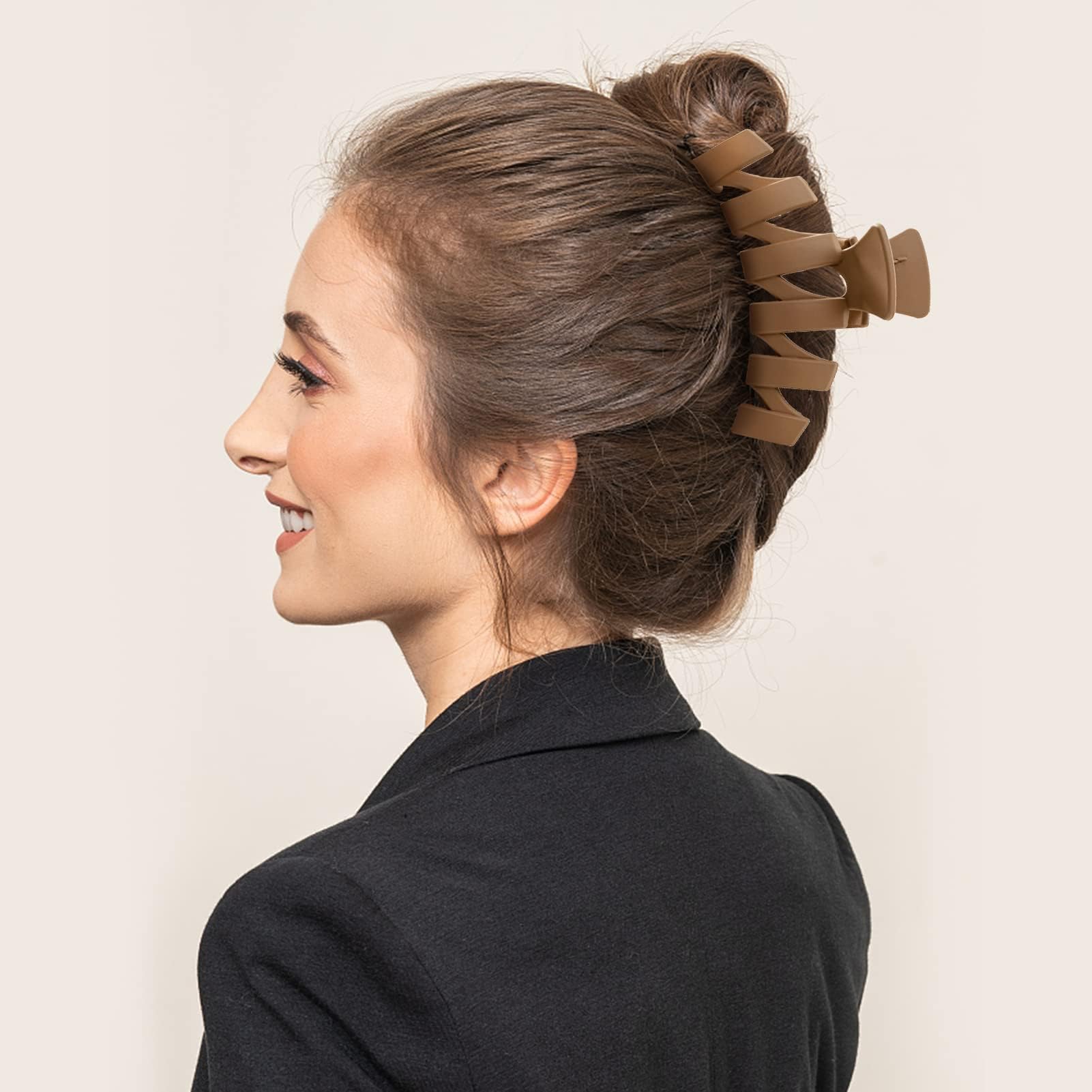 Close up view of the durable metal spring mechanism on a beige flower claw clip