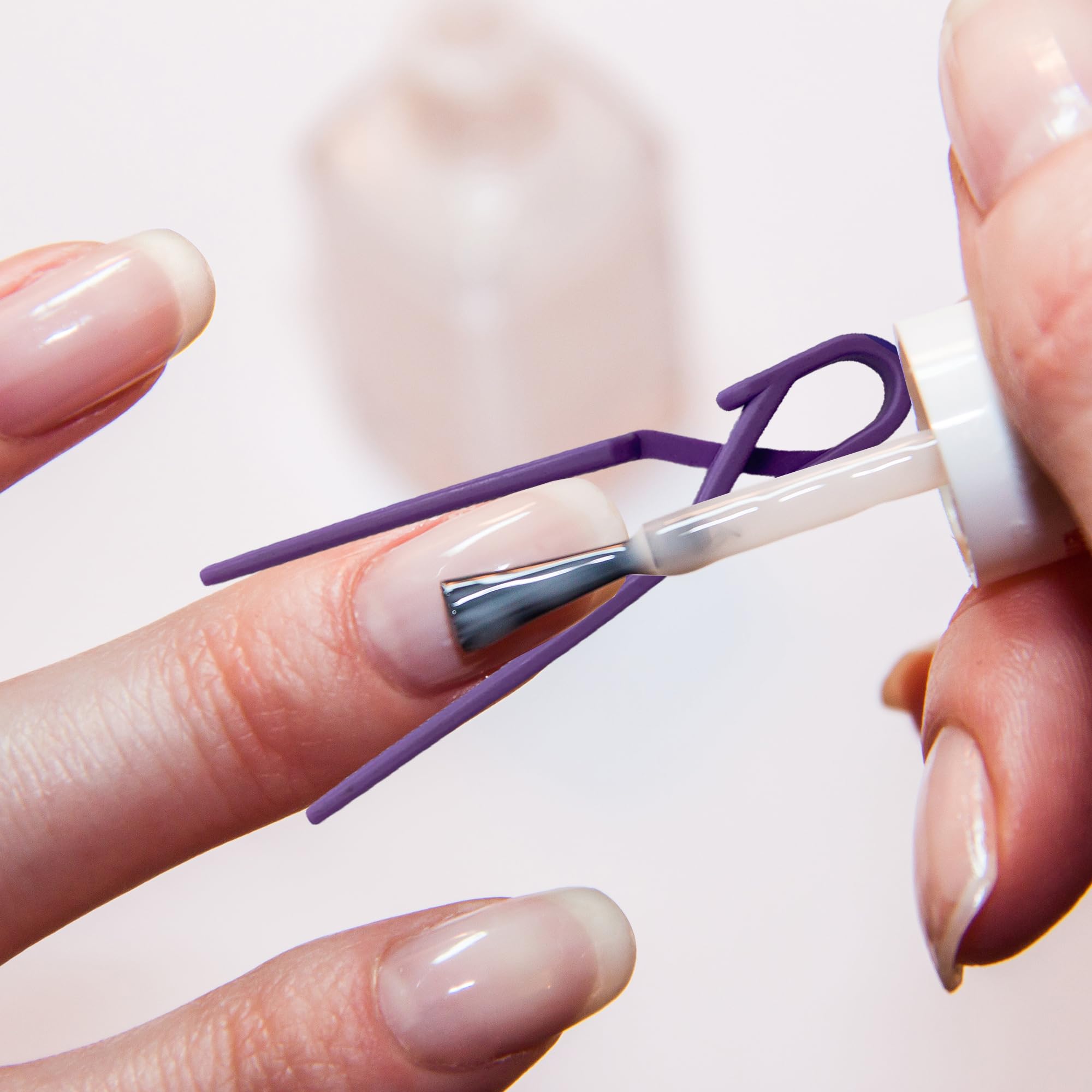 Close up of lavender plastic nail art shield applied on a fingertip for self doing manicures.