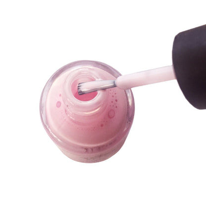 Pueen skin barrier protector drying to a clear pink hue during a home manicure session.