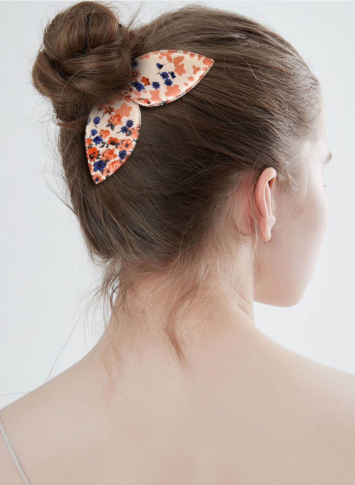 A woman showcasing a finished ballet donut updo using the quick styling accessory.