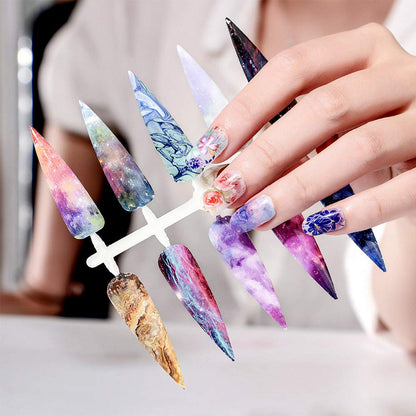 Kalolary nail art foil transfer stickers applied over dark gel polish under a professional salon UV LED lamp setup.