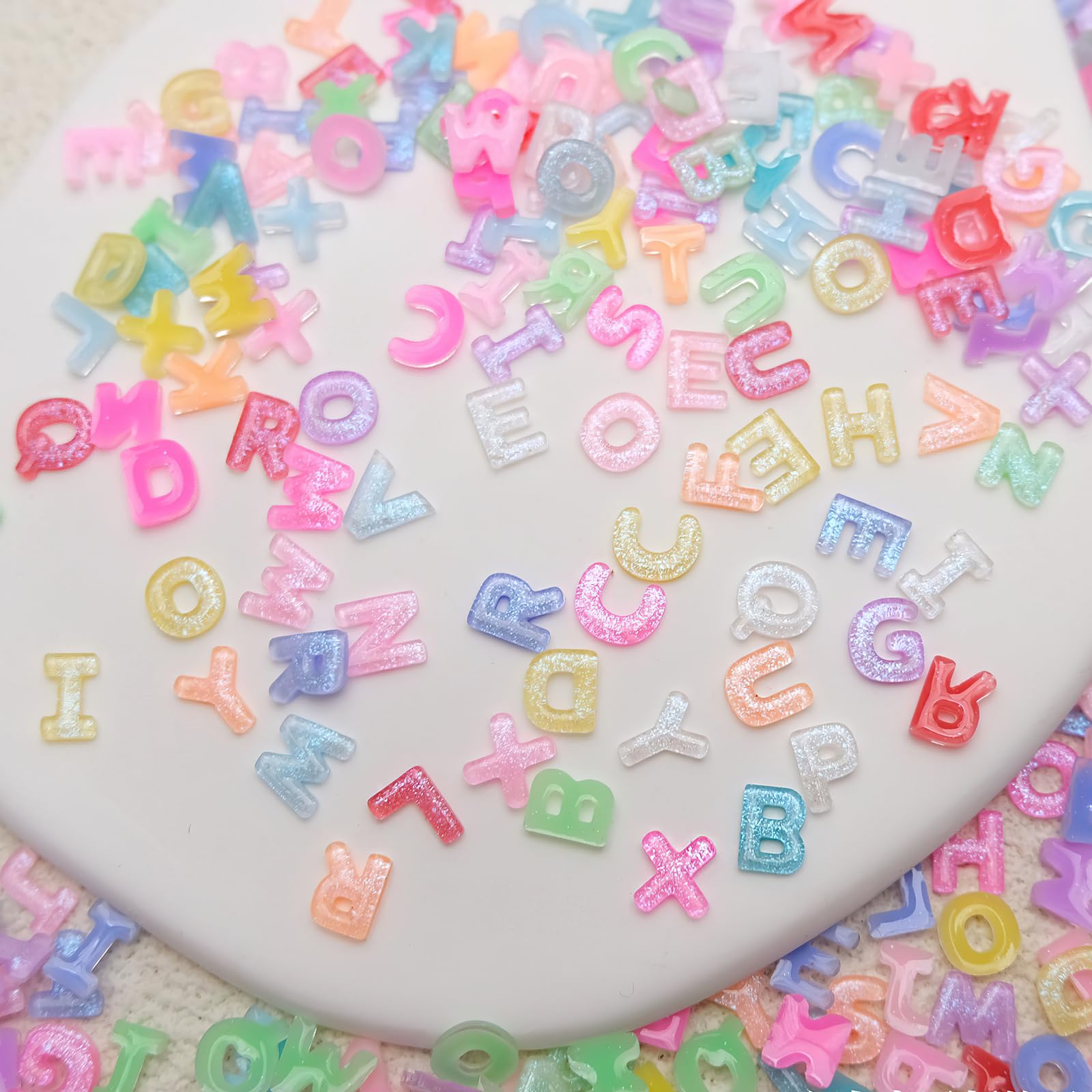 Close up of colorful resin alphabet nail gems