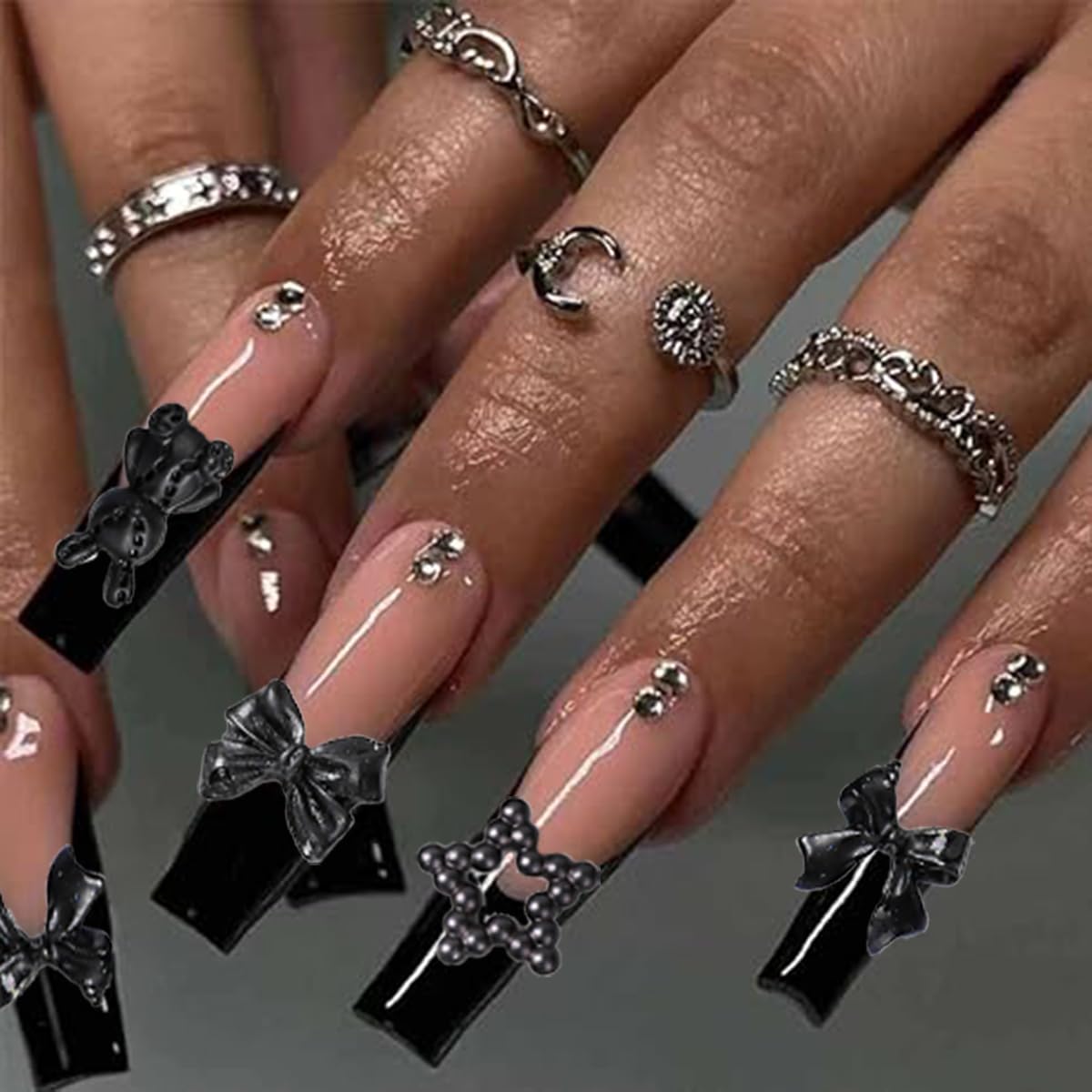 Demonstration of flatback resin butterfly embellishments applied seamlessly on long manicured gel extensions