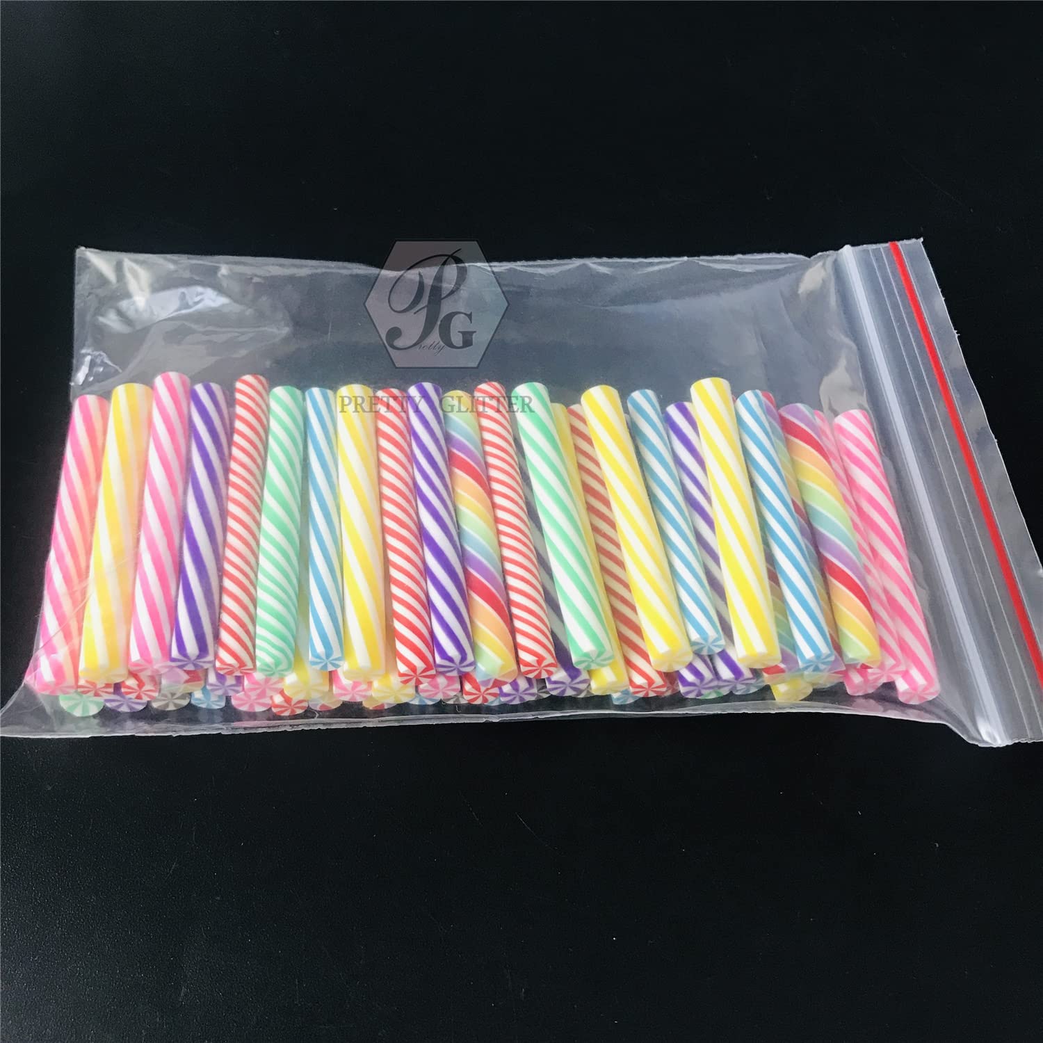 Colorful mixed fimo clay rods sliced into miniature candy cane shapes