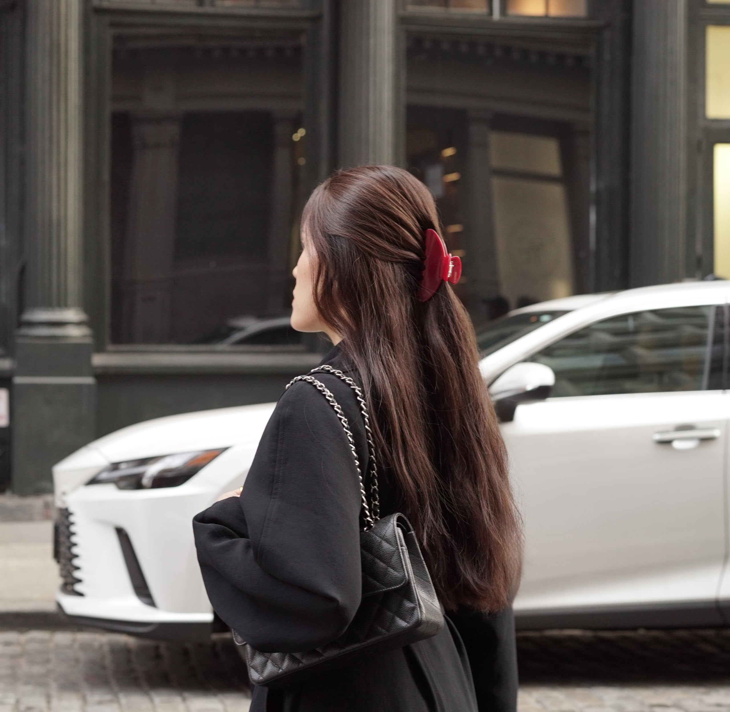 Model demonstrating half-up hairstyle with red claw clip