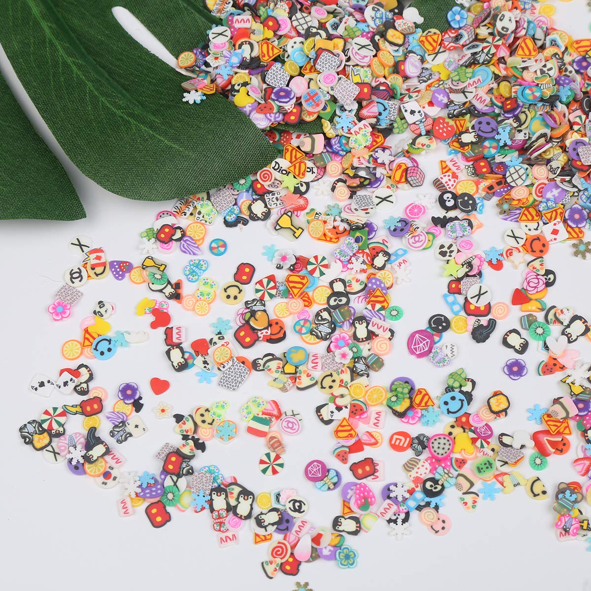 Close up view of diverse fimo clay slice designs including miniature fruits, flowers, and cartoon animals.
