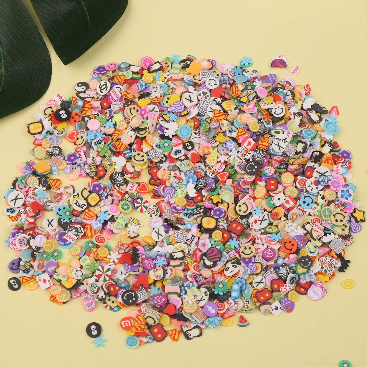 Different shapes of DIYASY 3D nail art embellishments spread out on a white crafting surface.