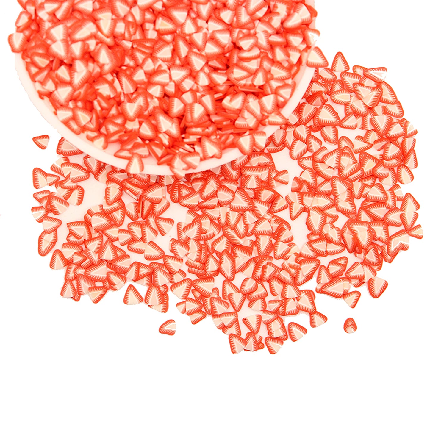 Close up view of red and white three dimensional polymer clay strawberry charms used for DIY slime decoration.