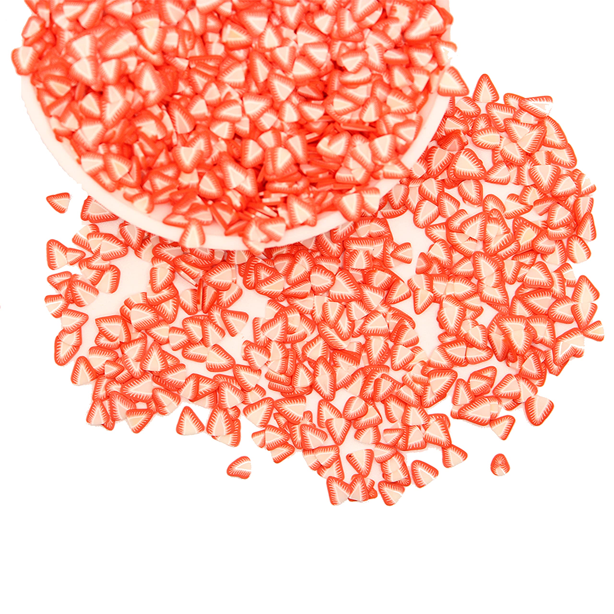 Close up view of red and white three dimensional polymer clay strawberry charms used for DIY slime decoration.