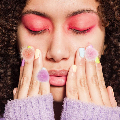Manicure model displaying a completed 3D nail art design featuring soft pink and white fluffy pompoms.