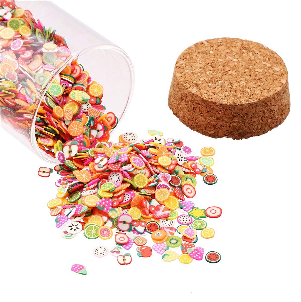 Hand mixing colorful mini fruit charms into clear slime base for satisfying textured sensory play craft