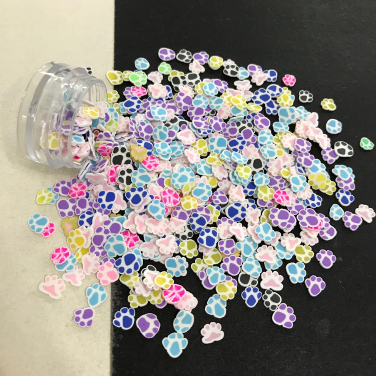 Vibrant animal paw print polymer fimo clay slices scattered closely to show design detail.