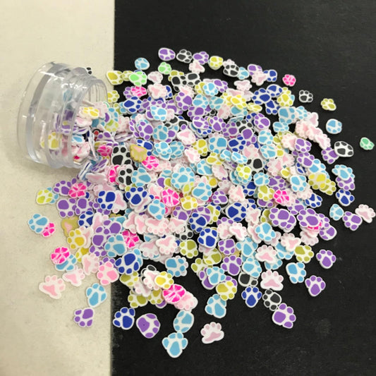 Vibrant animal paw print polymer fimo clay slices scattered closely to show design detail.