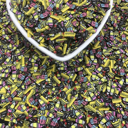 Close up view of PrettyG school themed polymer charms embedded inside clear DIY slime for texture comparison.