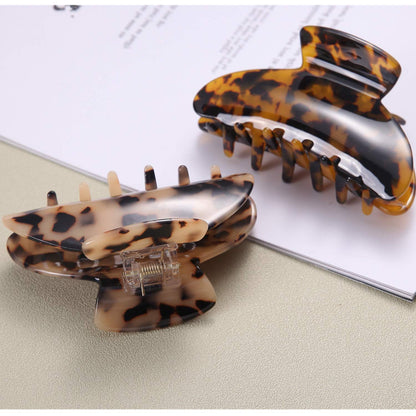 Two Fsmiling claw clips arranged on a flat surface