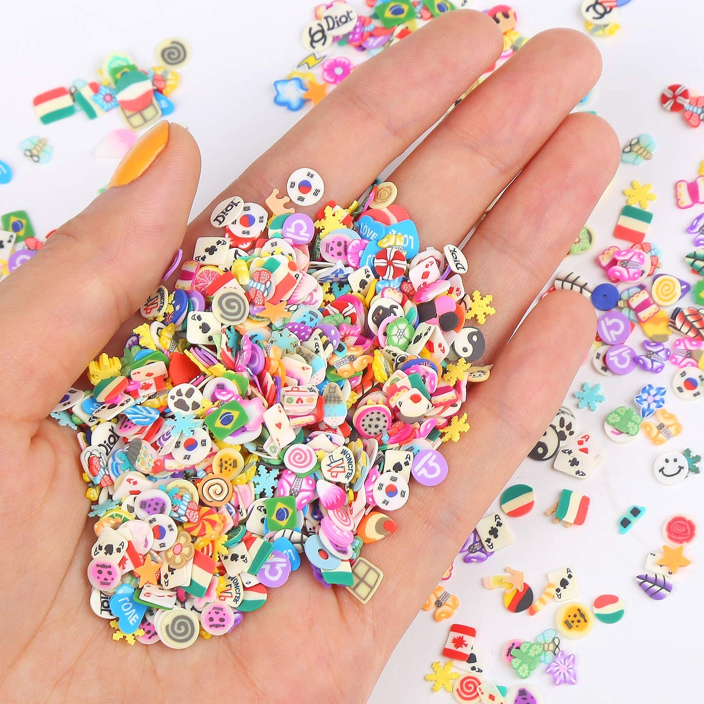 Close up view of detailed miniature lemon, strawberry, and flower nail art charms
