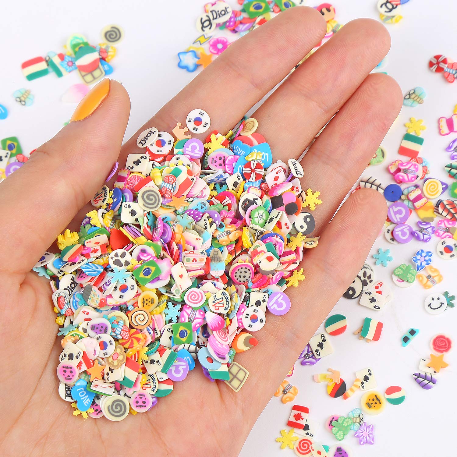 Close up view of detailed miniature lemon, strawberry, and flower nail art charms