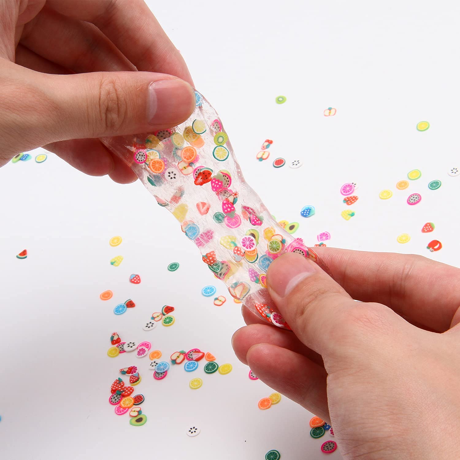 Vibrant multicolor polymer clay fruit slices mixed into clear crunchy slime base