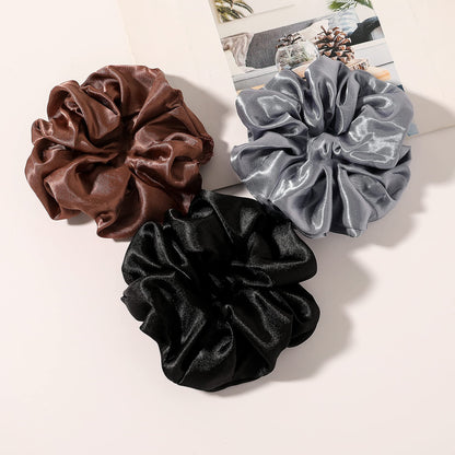 Ivyu neutral satin scrunchies being worn comfortably around a wrist.