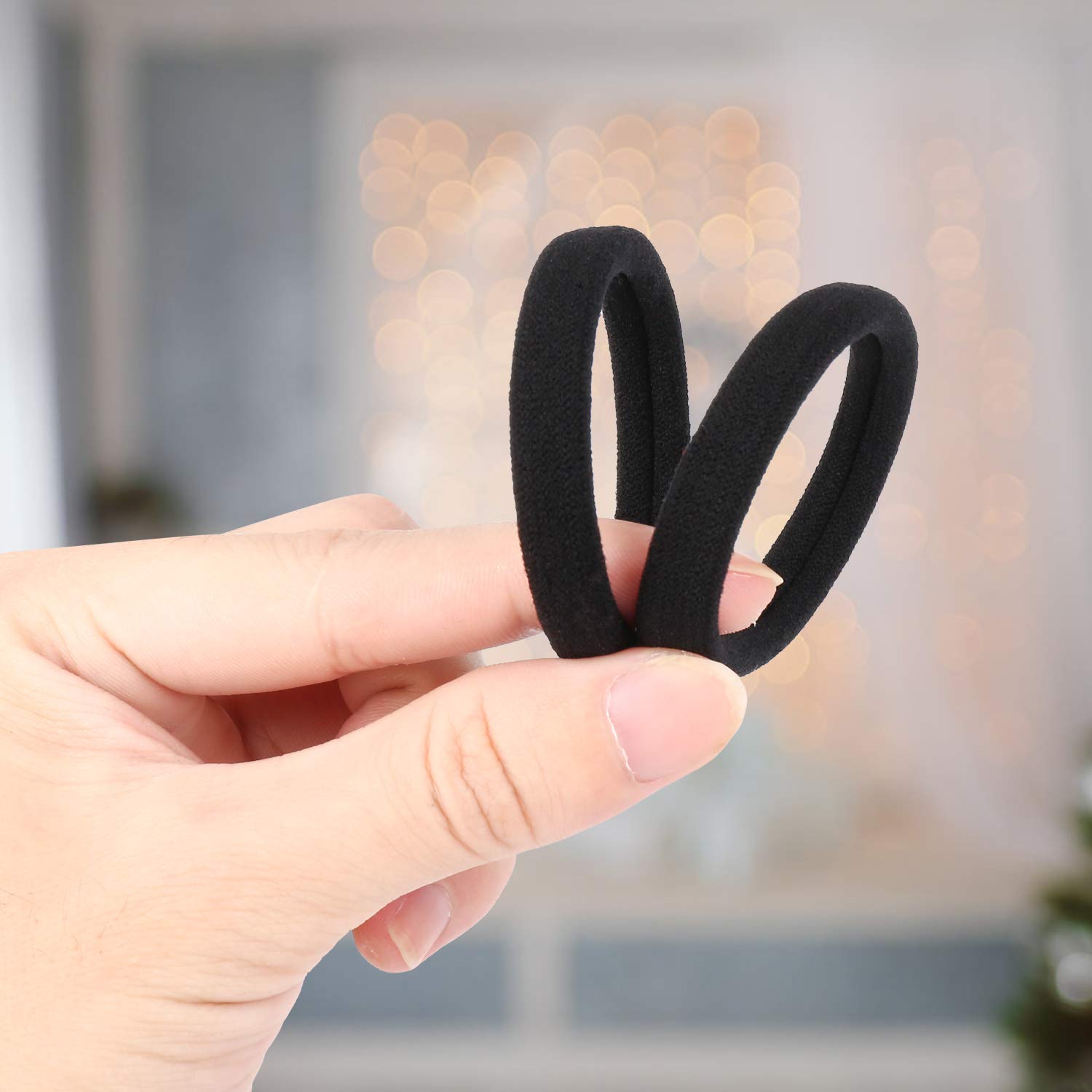 Durable cotton ponytail holders being stretched to demonstrate strong elasticity for thick hair types