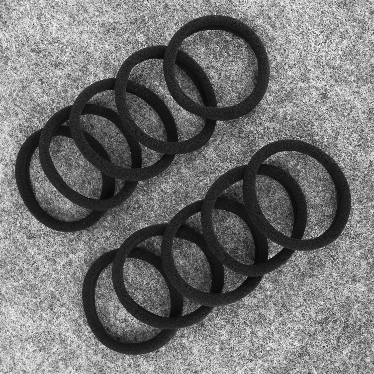 Side view of multiple premium snag free black hair elastics grouped together for volume comparison