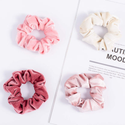 Model with thick curly hair wearing a pink Whaline velvet scrunchie in a high ponytail.