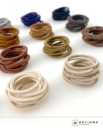 Heliums mini black hair ties being used for a kids multi section ponytail hairstyle