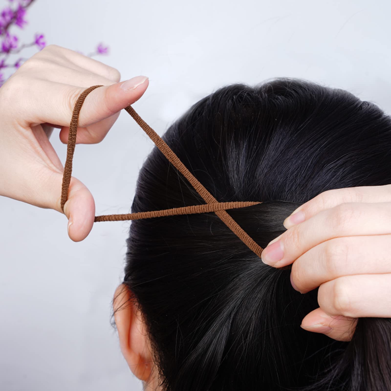Model demonstrating a secure damage free high ponytail hairstyle using a thick black band.