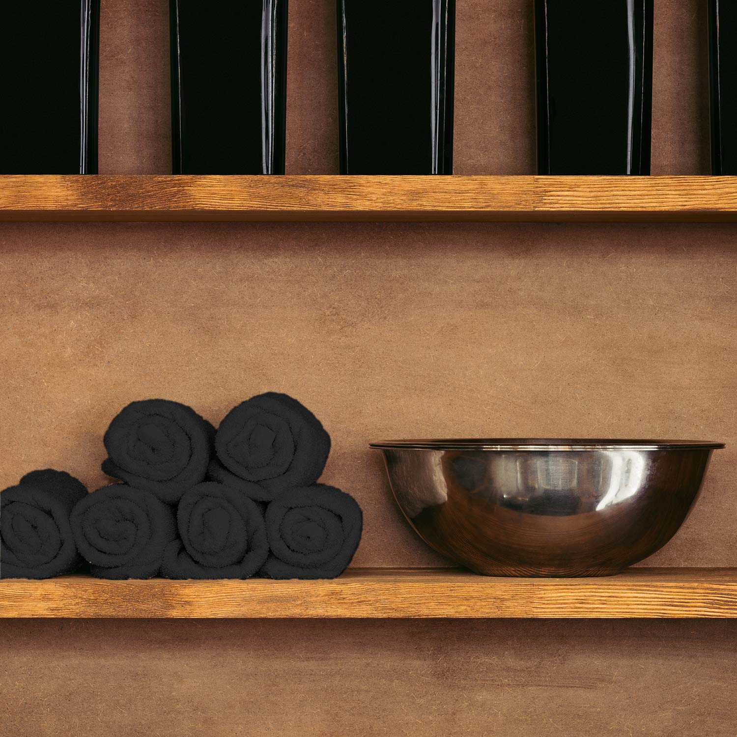 Absorbent black cotton hand towel draped over a salon chair armrest.