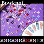 Close-up view of multicolored resin bow and flower nail art charms.