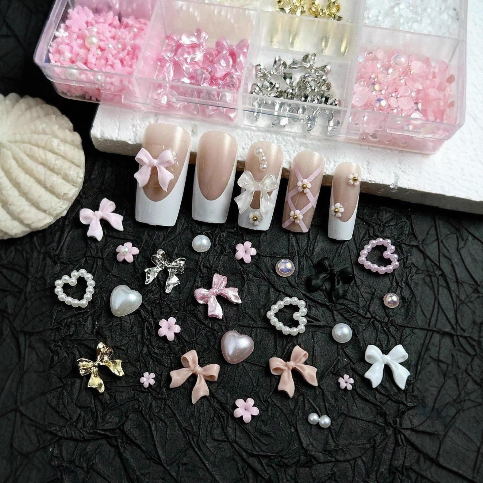 Close-up view of 3D resin bow charms and pearls for manicure design.