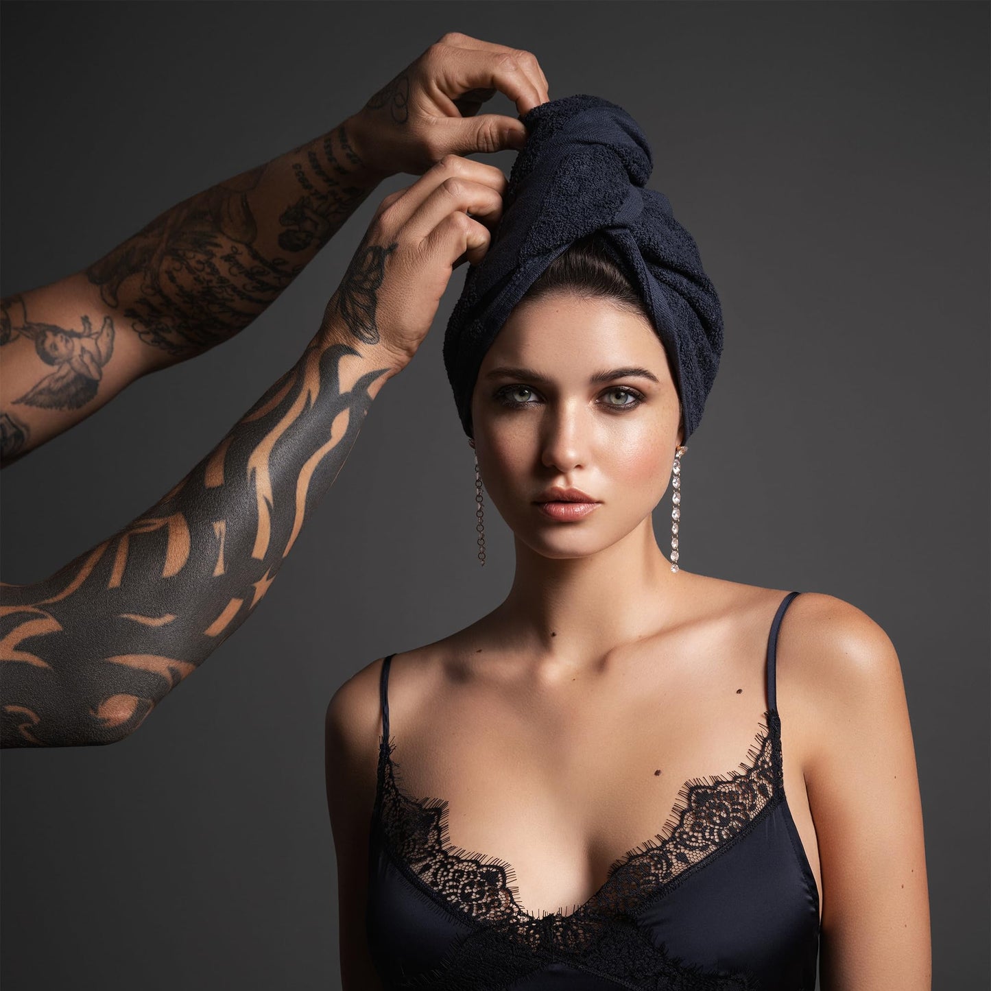 Stack of 6 black Fromm hair towels for professional salon use