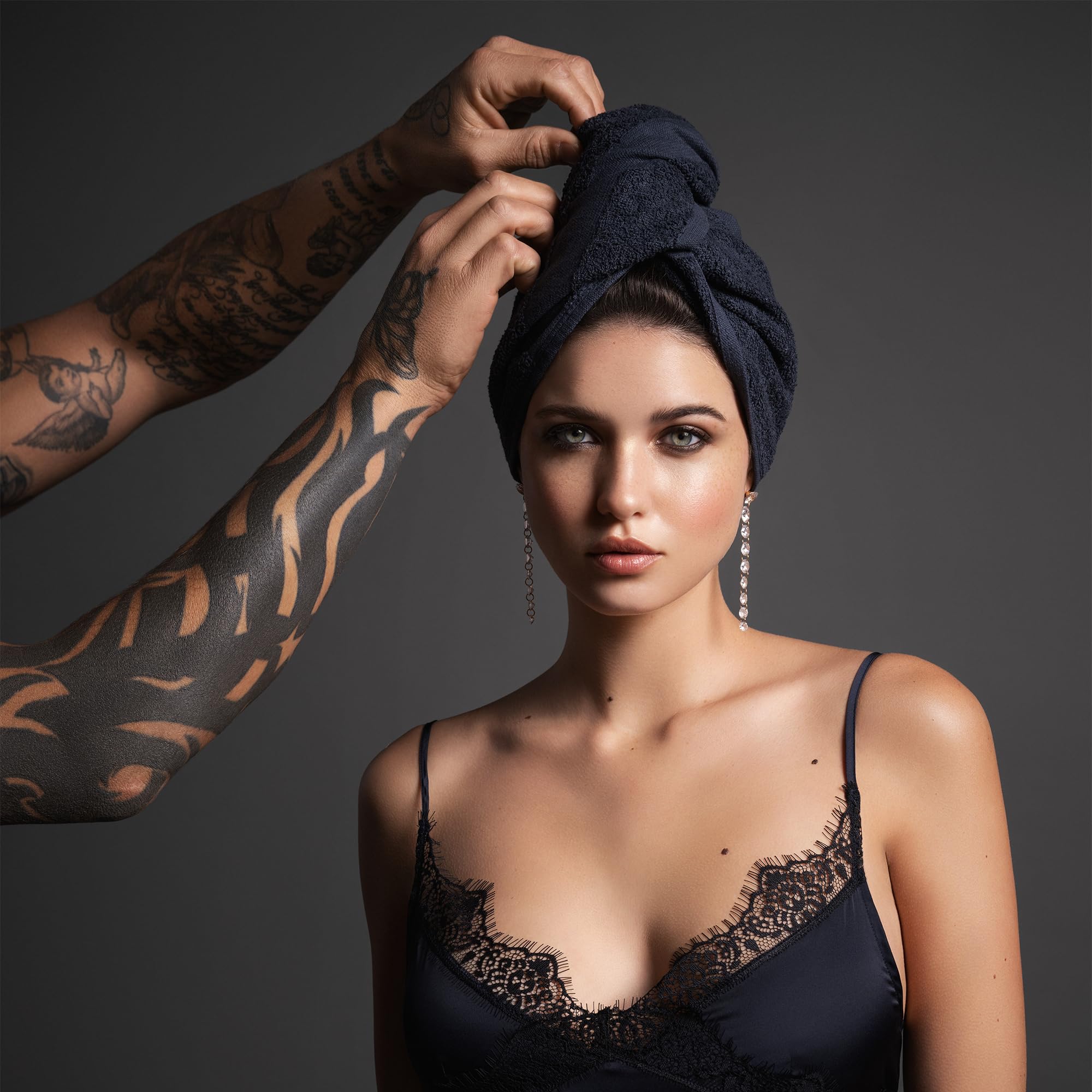 Stack of 6 black Fromm hair towels for professional salon use