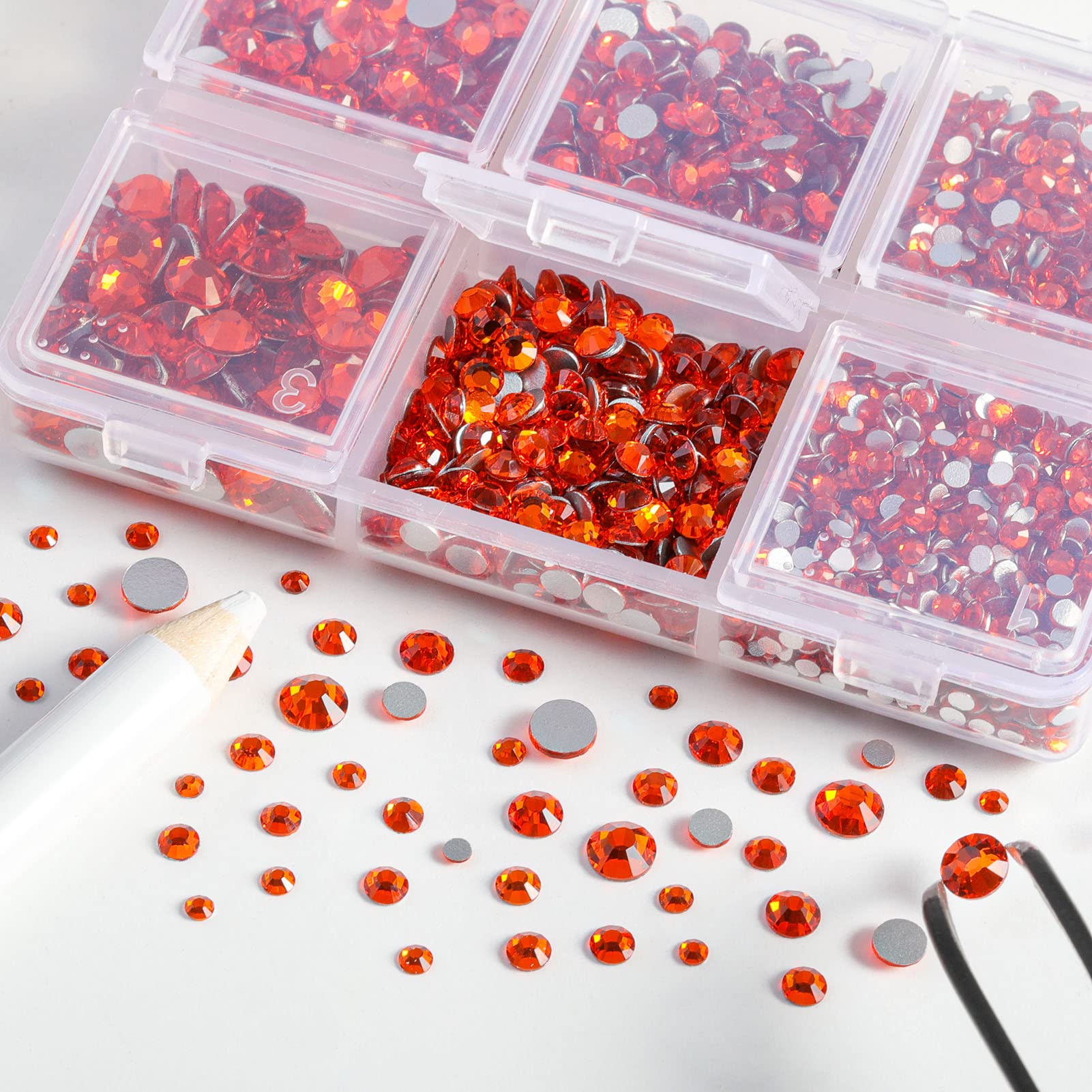 Close up of Beadsland orange glass crystals with tweezers and wax pen