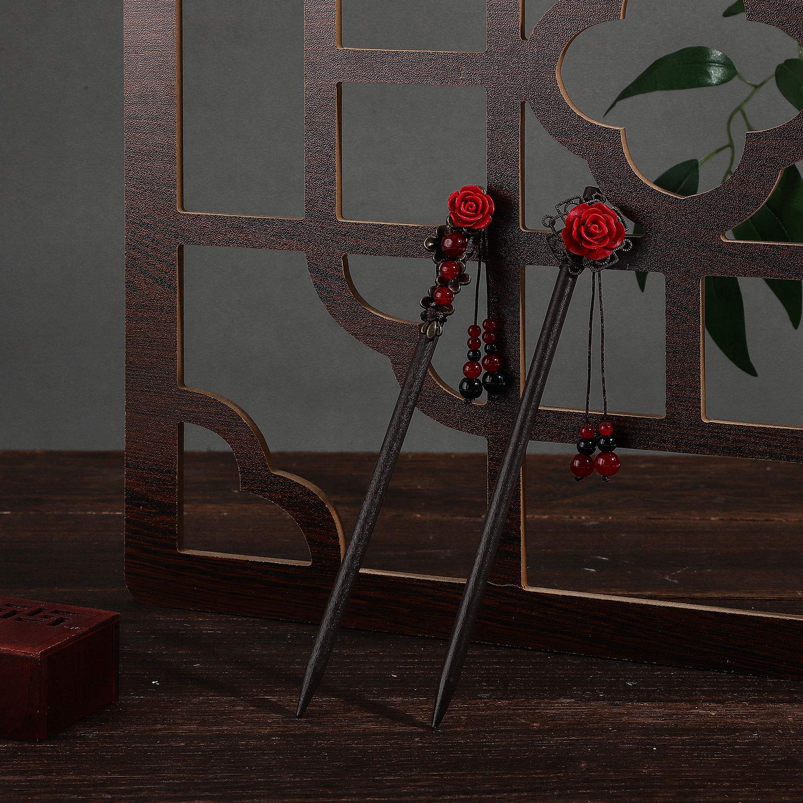 A pair of handmade floral wooden hair sticks showcasing the unique patterns and detailed styling elements.