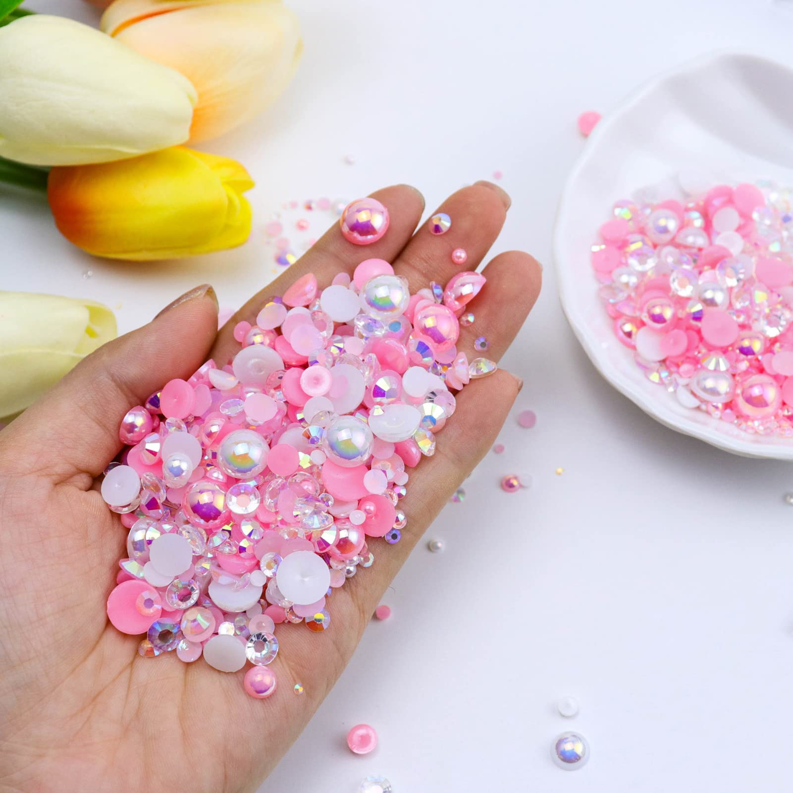 Assorted pink and white rhinestones and pearls close up