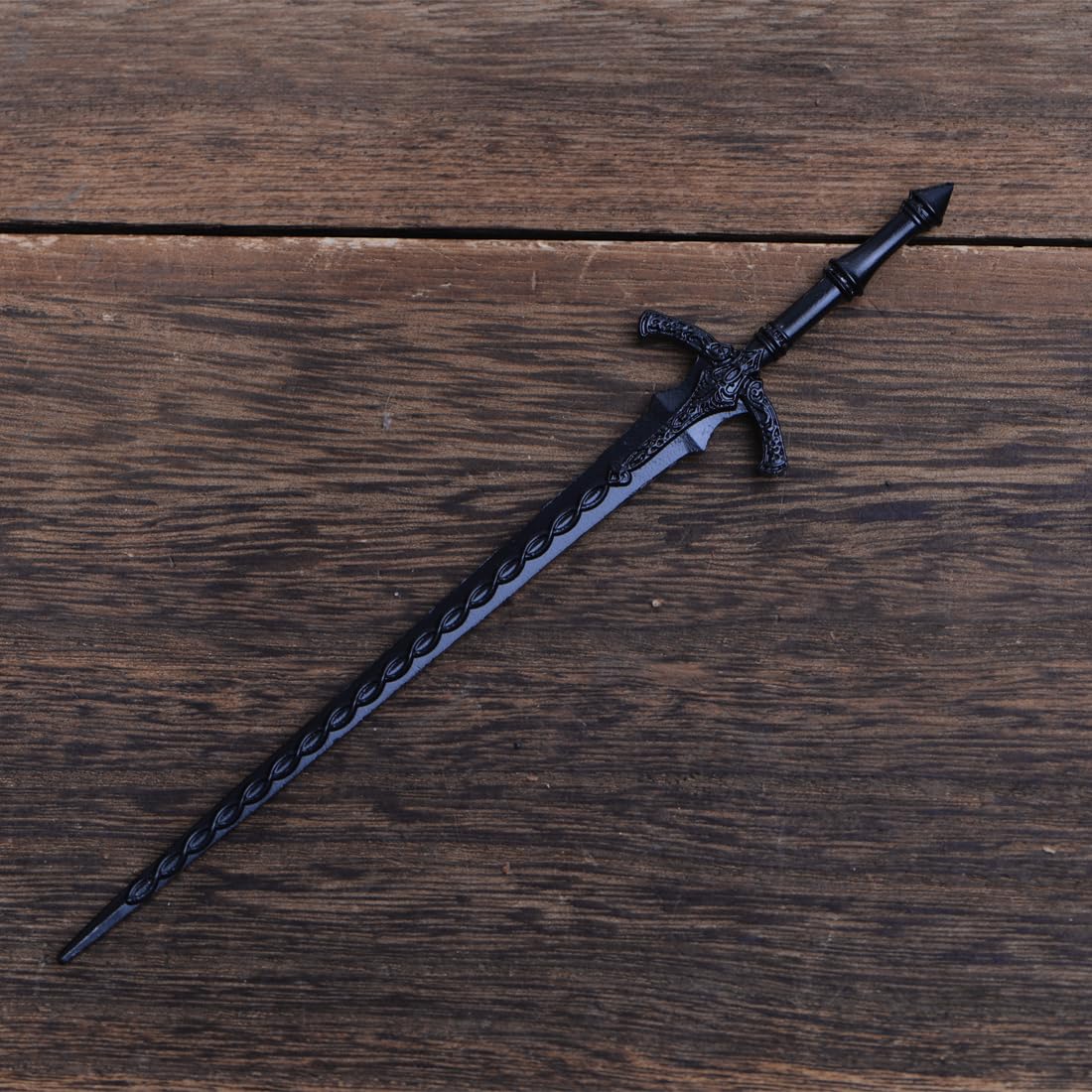 Durable zinc alloy metal sword styling pin being held to demonstrate the sturdy thickness and premium quality