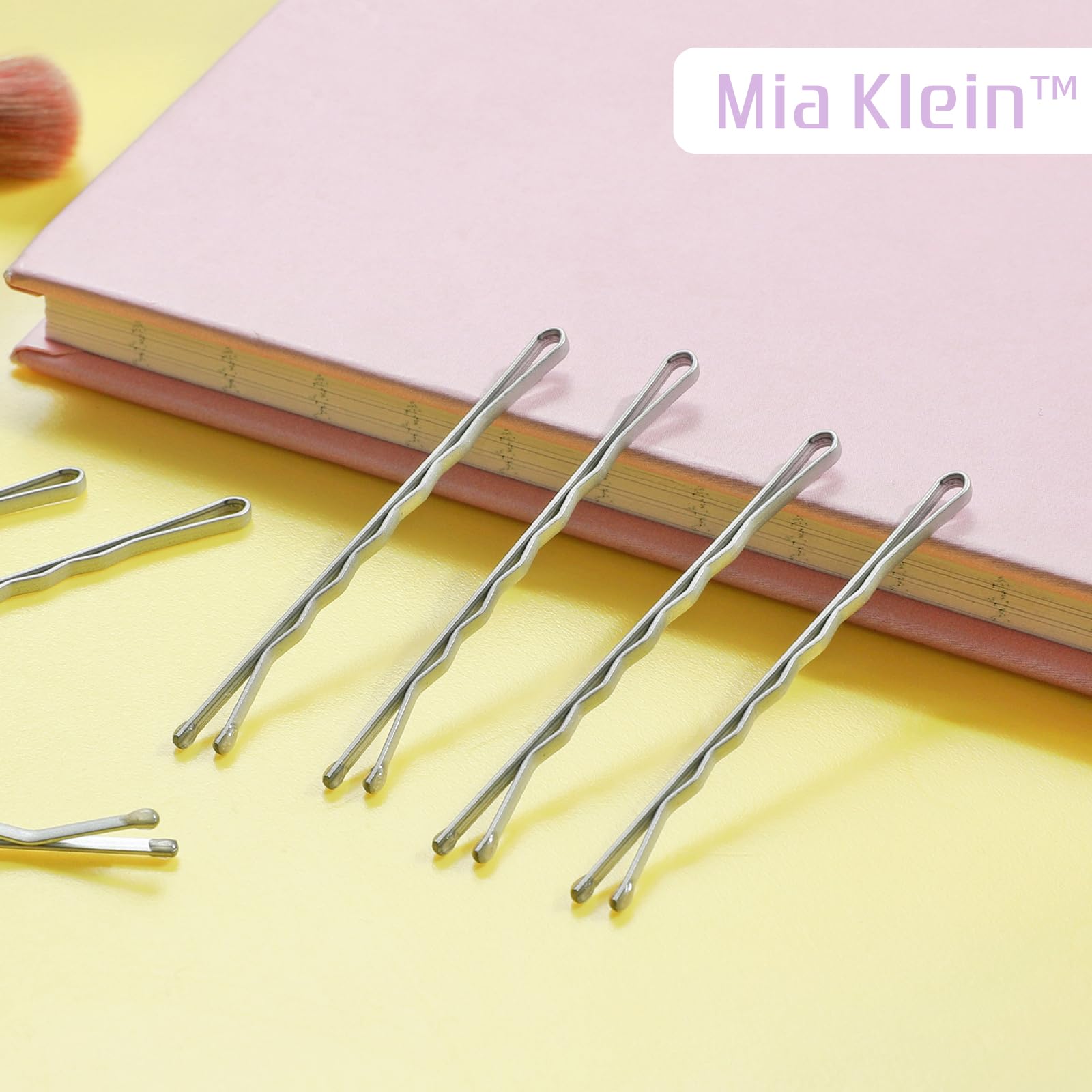 Sixty piece pack of silver bobby pins spread out on surface