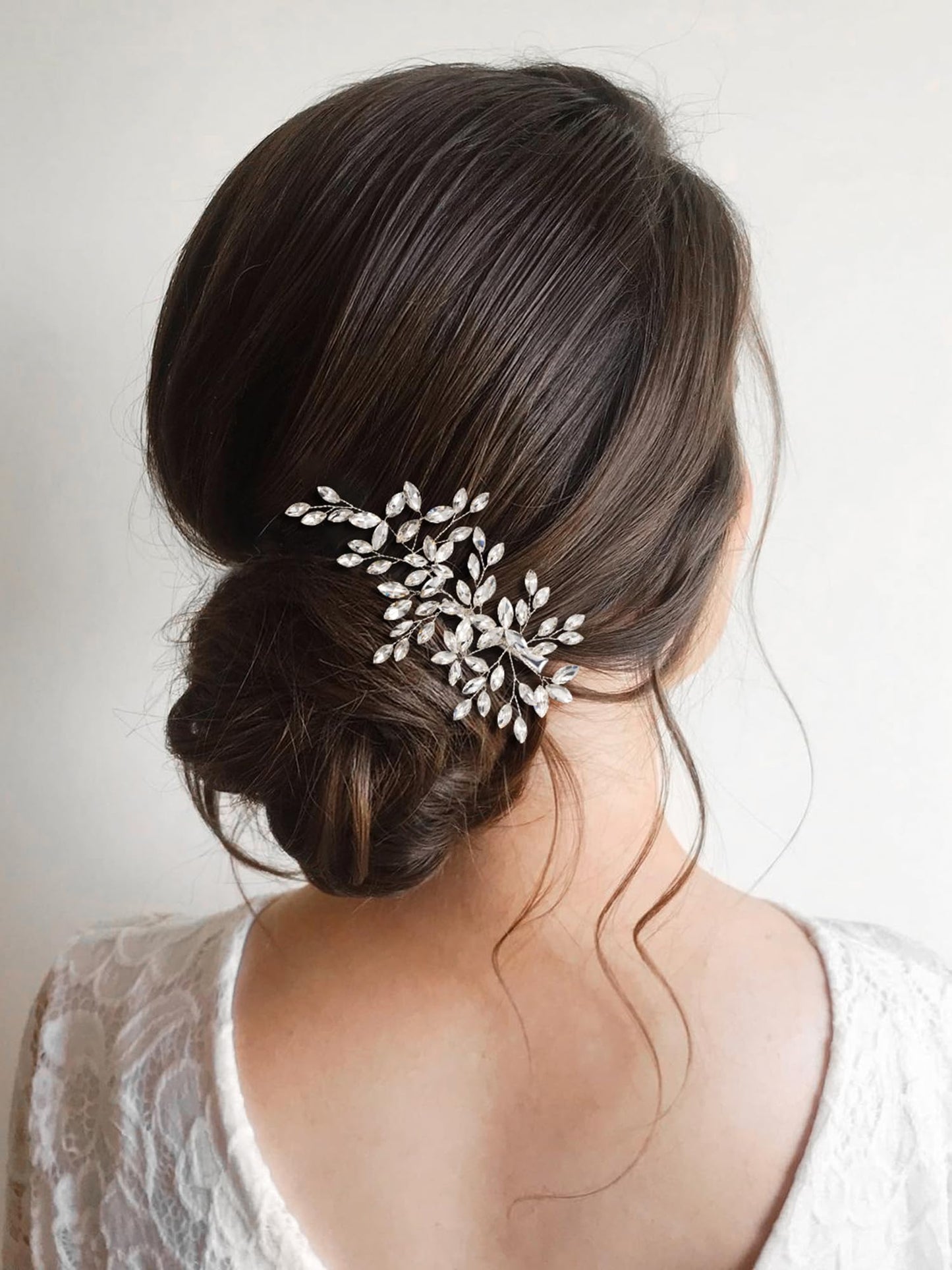 Elegant silver wedding hair clip positioned on an elegant bridal bun hairstyle