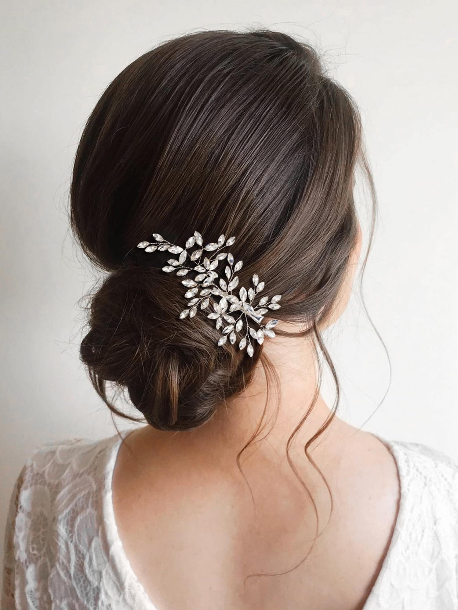 Elegant silver wedding hair clip positioned on an elegant bridal bun hairstyle