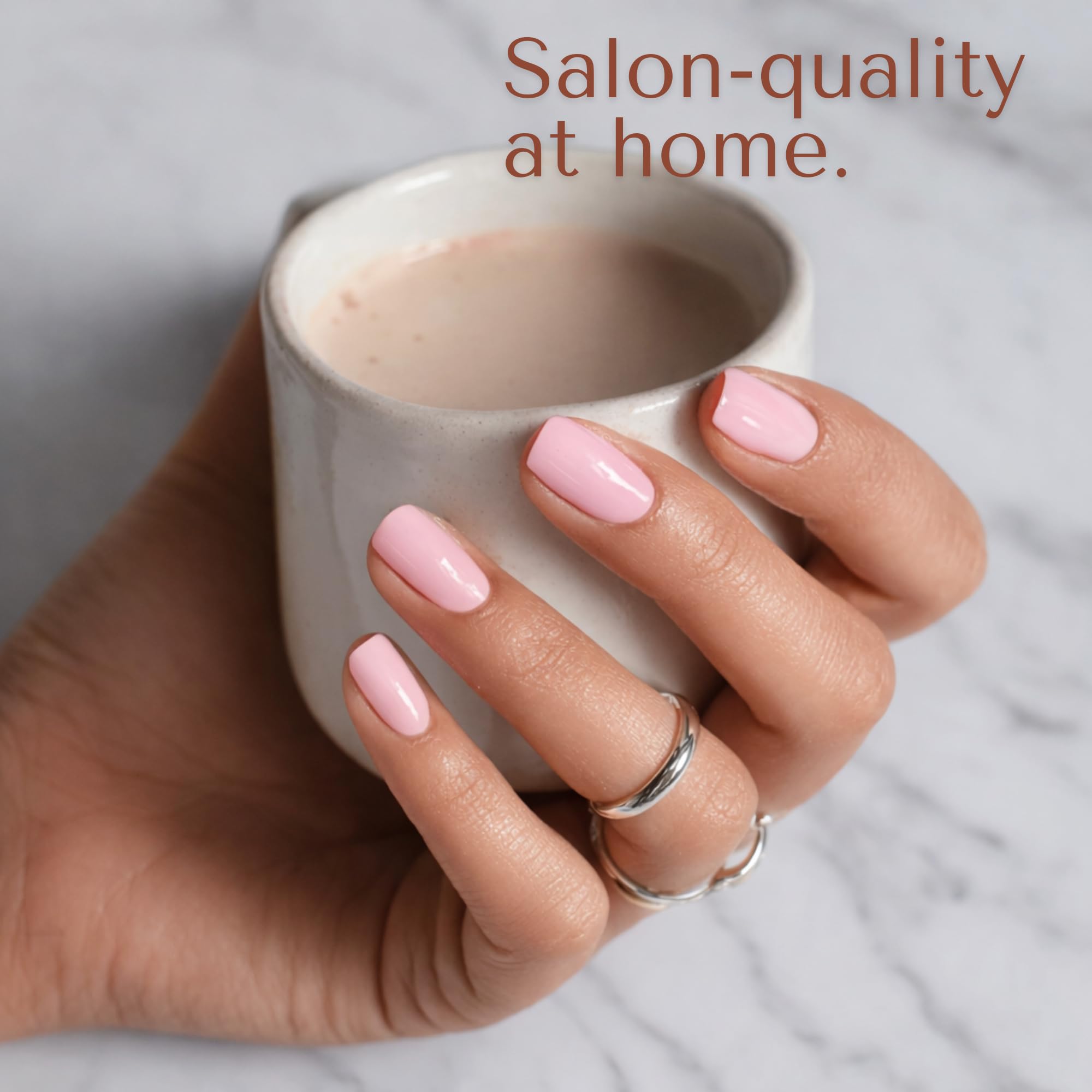 Model showcasing a completed light pink glossy manicure using Blushing Bunny semi cured strips.