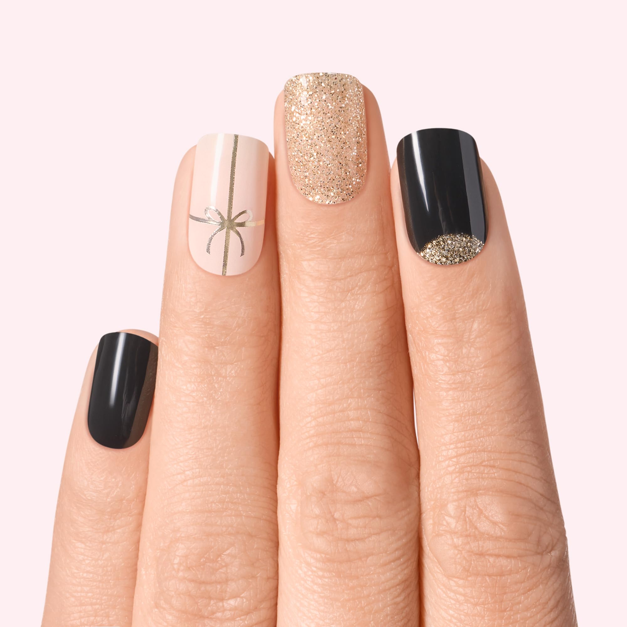Close up view of Dashing Diva semi-cured gel strips in Old Gold holiday design featuring sparkling accents.