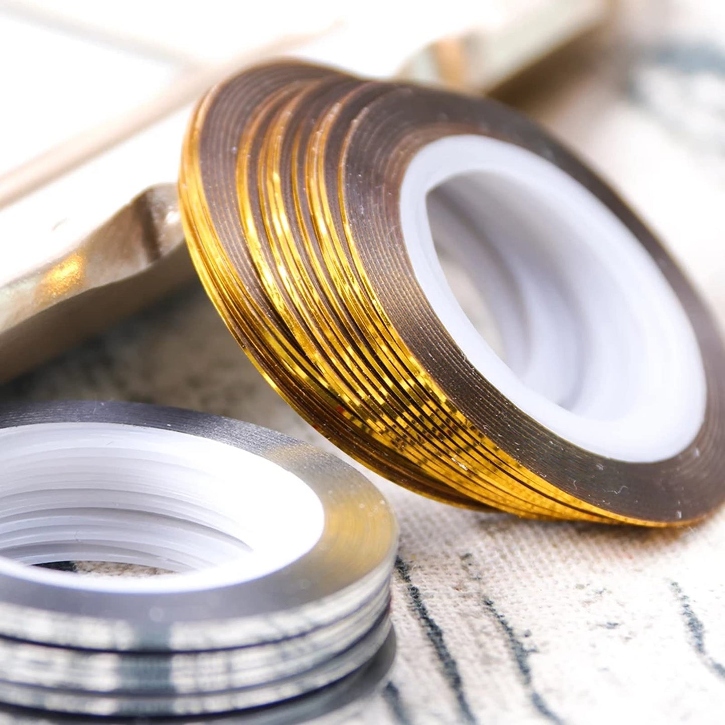 Assorted rolls of gold and silver nail decoration strips for professional nail art